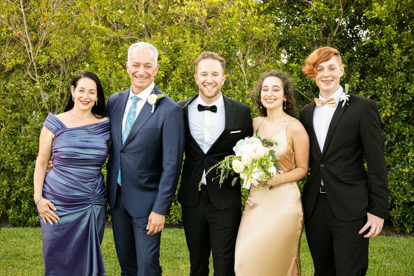 Meir Ezra with his family, dressed for a celebration in a garden